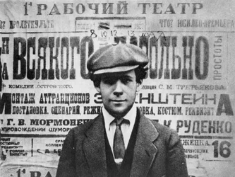 Sergei Eisenstein (1898-1948) na frente de um cartaz para a peça, Sagesse, 1923, de Serge Eisenstein, Reflexions dun Cineaste, publicado em Moscou, 1958